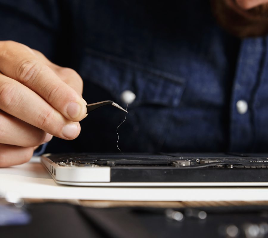 Close focus on angled esd tweezers with long hair removed from broken cooler of electronic device in service center